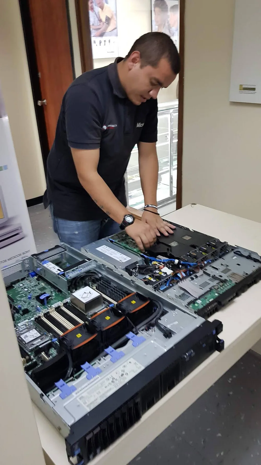 Soportered field work: technician servicing an open server